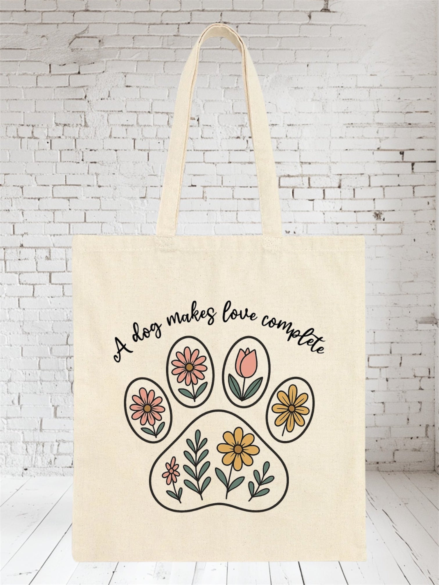 Beige canvas tote bag with floral paw design and "A dog makes love complete" text