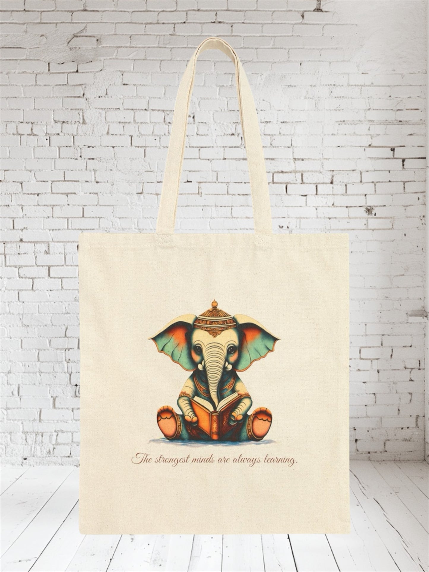 Canvas Tote bag with an elephant reading design, "The strongest minds are always learning."